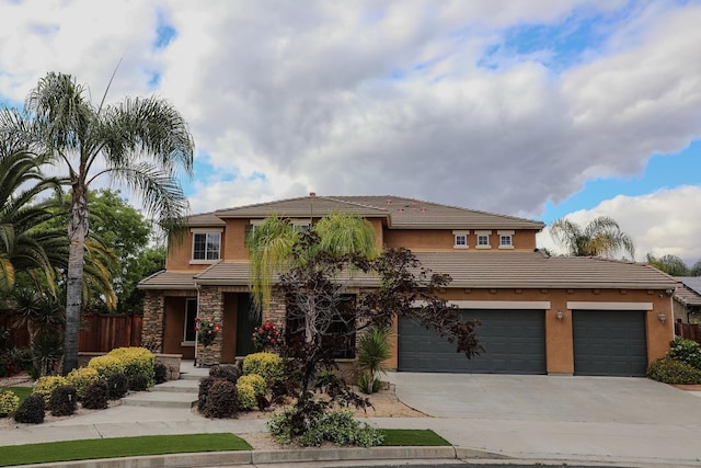 prairie-style home with a tile roof, fence, driveway, and stucco siding