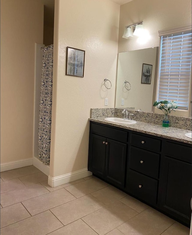 5244 W Fern Ave, Fresno, CA 93722 - bathroom with vanity, baseboards, tile patterned floors, and curtained shower