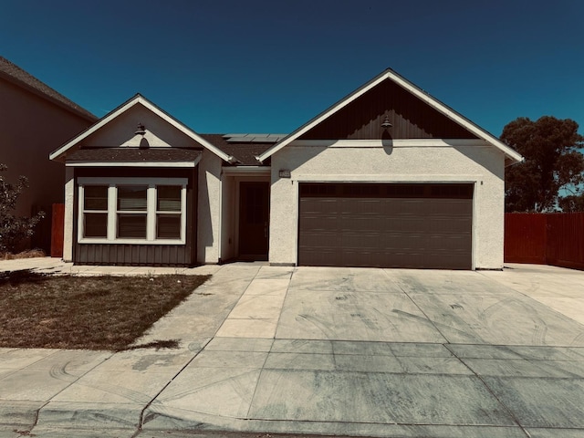 5244 W Fern Ave, Fresno, CA 93722 - ranch-style home featuring stucco siding, driveway, solar panels, and a garage