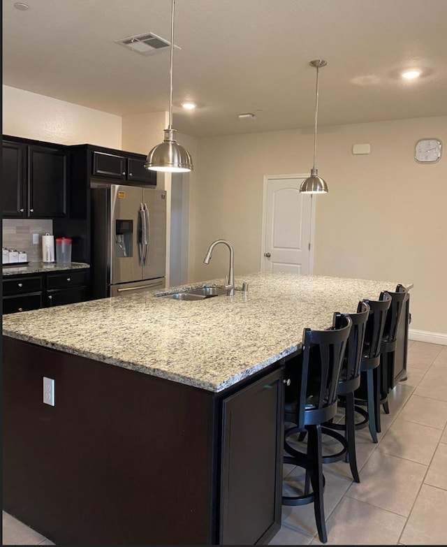 5244 W Fern Ave, Fresno, CA 93722 - kitchen with visible vents, a large island, stainless steel fridge, a sink, and light tile patterned floors