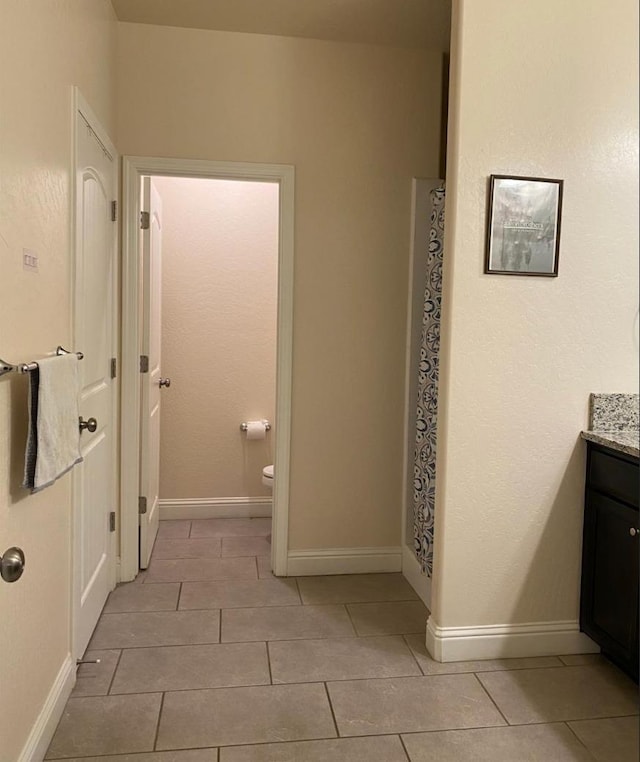5244 W Fern Ave, Fresno, CA 93722 - bathroom featuring toilet, baseboards, tile patterned flooring, and vanity
