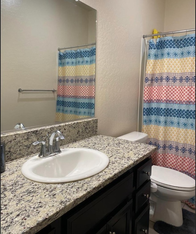 5244 W Fern Ave, Fresno, CA 93722 - bathroom with vanity, a textured wall, a shower with shower curtain, and toilet