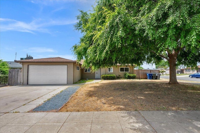 ranch-style house featuring stucco siding, a garage, fence, and concrete driveway