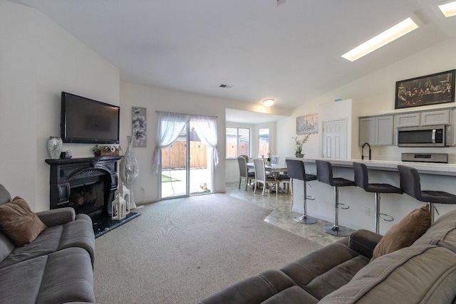 6577 E Kerckhoff Ave, Fresno, CA 93727 - living room with vaulted ceiling, visible vents, and a fireplace