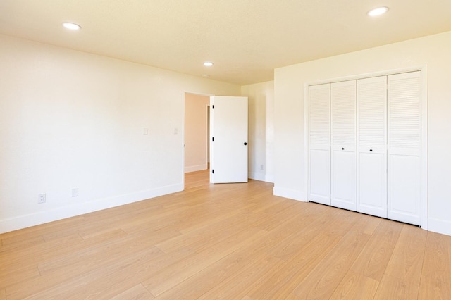 unfurnished bedroom featuring recessed lighting, baseboards, light wood finished floors, and a closet