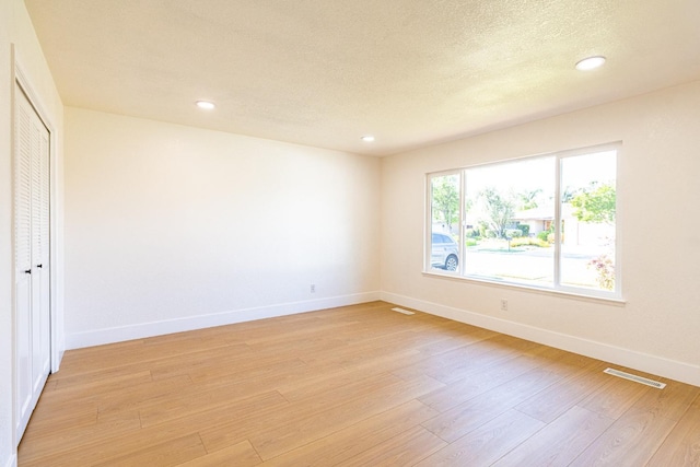 unfurnished bedroom featuring visible vents, light wood-style flooring, baseboards, and recessed lighting