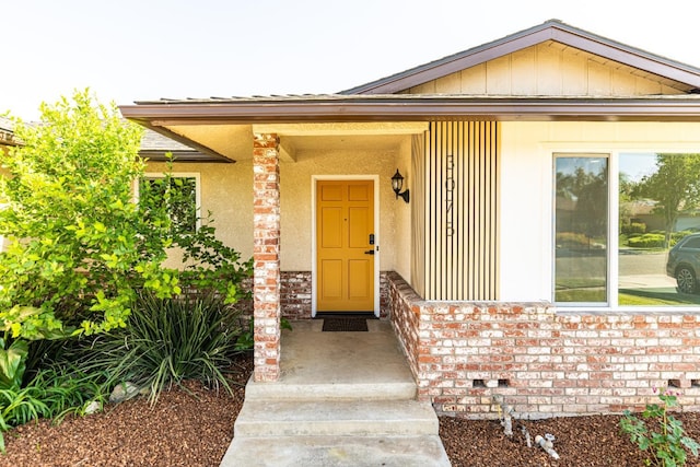 doorway to property featuring brick siding
