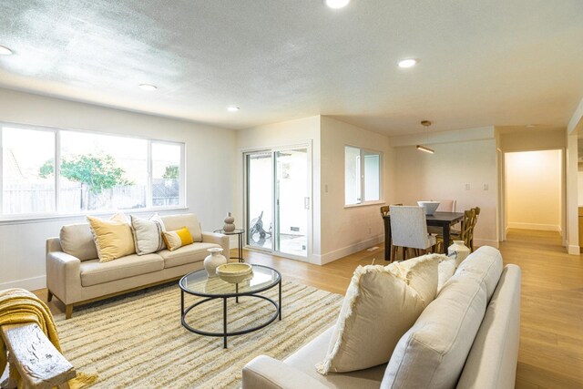 living area with recessed lighting, baseboards, and plenty of natural light