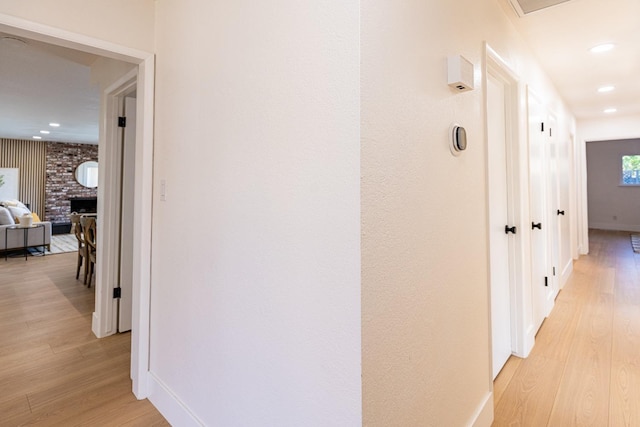 hallway with recessed lighting, baseboards, and light wood-type flooring