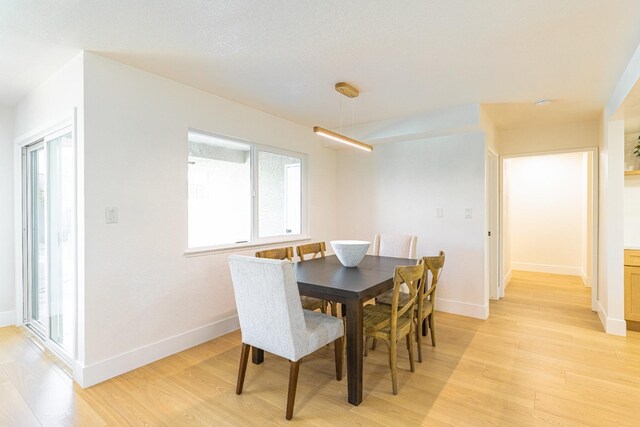 dining room with baseboards and light wood-style flooring