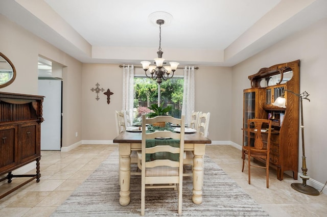 dining space with baseboards, a chandelier, light tile patterned floors, and a raised ceiling