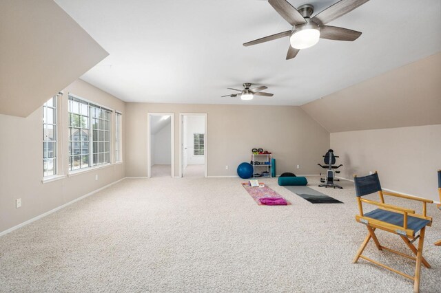 interior space featuring baseboards, carpet flooring, ceiling fan, and vaulted ceiling