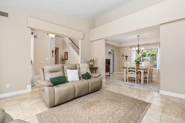 tiled living room with baseboards, visible vents, stairs, and a chandelier
