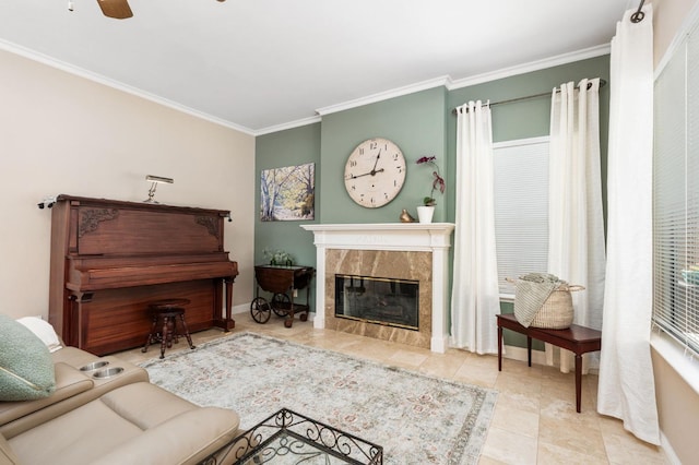 tiled living area featuring baseboards, ornamental molding, a fireplace, and a ceiling fan