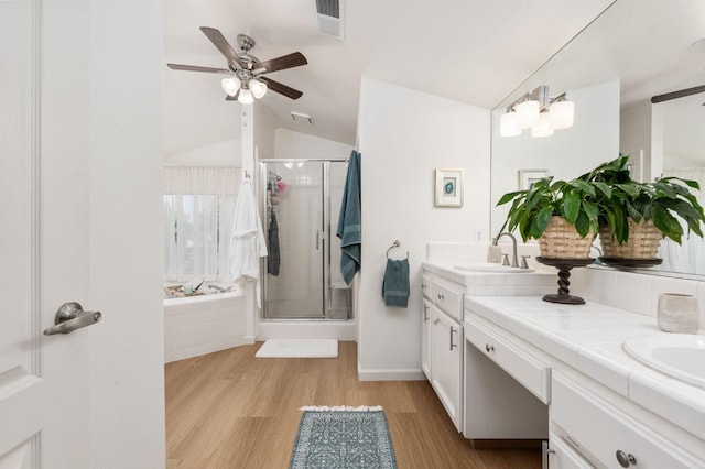 full bathroom with double vanity, lofted ceiling, ceiling fan, a sink, and a stall shower