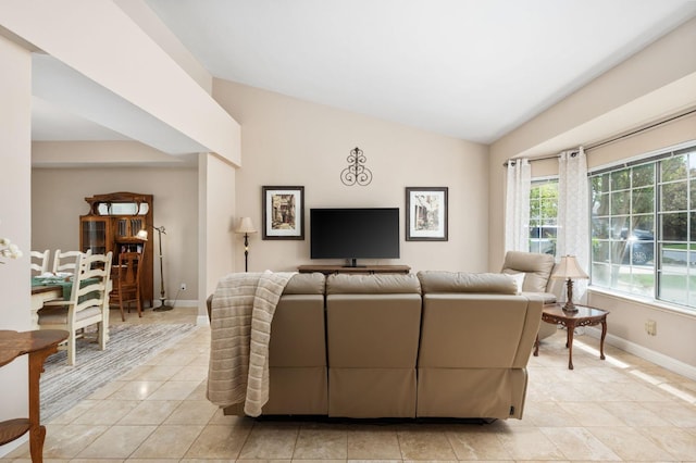 living area featuring light tile patterned flooring, baseboards, and vaulted ceiling