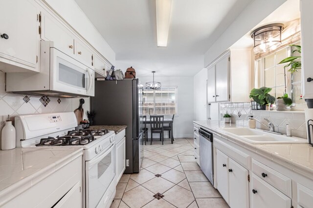 927 W Pico, Clovis, CA 93612 - kitchen featuring a sink, stainless steel appliances, tile countertops, and white cabinetry