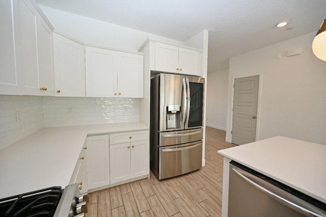 kitchen with light countertops, white cabinetry, stainless steel appliances, and tasteful backsplash