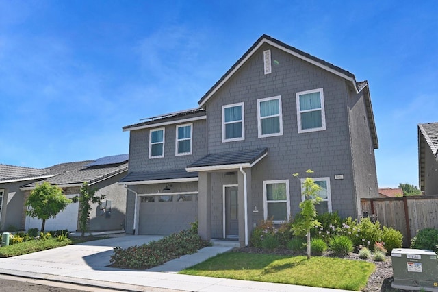traditional home with concrete driveway, a garage, and fence