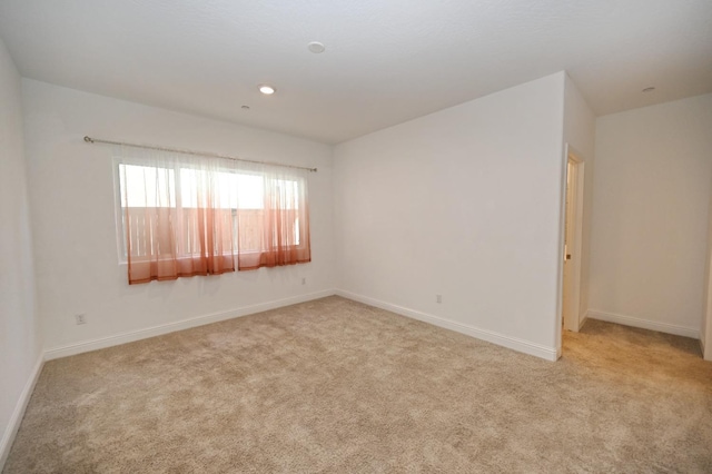 unfurnished room featuring light carpet, baseboards, and recessed lighting