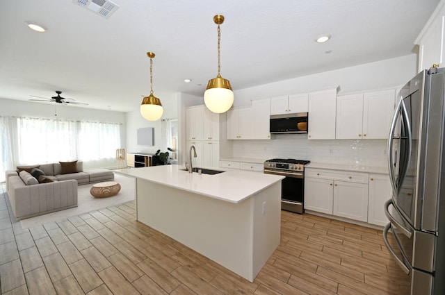 kitchen featuring a sink, visible vents, open floor plan, light countertops, and appliances with stainless steel finishes