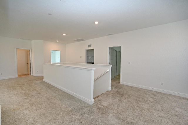 empty room with baseboards, light carpet, and recessed lighting