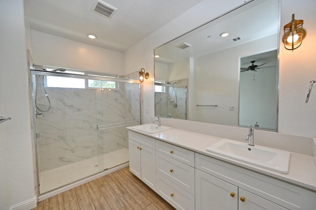 full bath with a marble finish shower, visible vents, and a sink