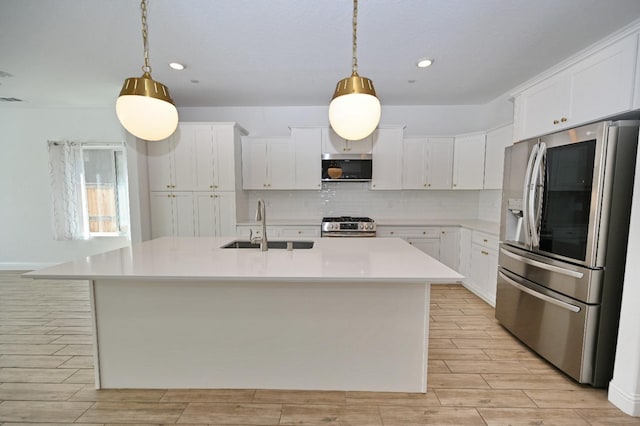 kitchen featuring appliances with stainless steel finishes, a sink, light countertops, tasteful backsplash, and light wood-type flooring