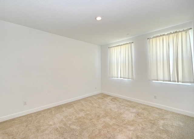 unfurnished room with baseboards, light carpet, and recessed lighting