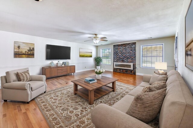 301 W Paul Ave, Clovis, CA 93612 - living room featuring a ceiling fan, baseboards, light wood finished floors, and a fireplace