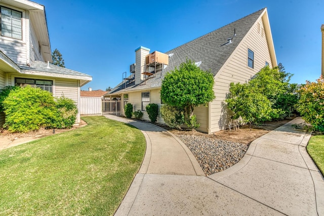 301 W Paul Ave, Clovis, CA 93612 - view of side of home featuring a shingled roof, fence, and a yard