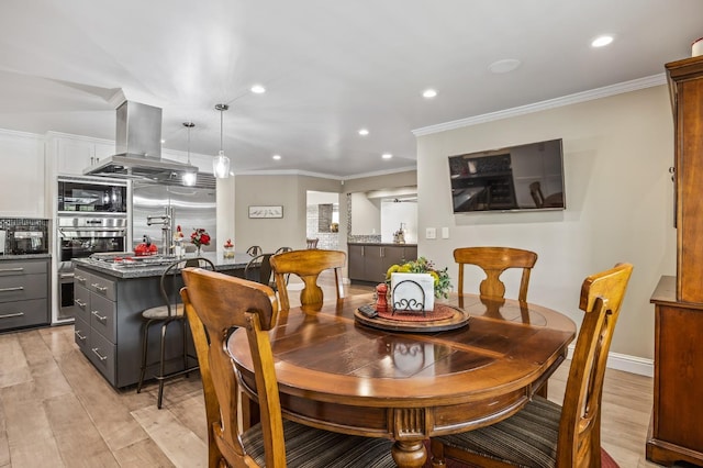 dining room with recessed lighting, ornamental molding, and light wood-style floors