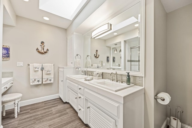full bath with decorative backsplash, double vanity, baseboards, recessed lighting, and a sink