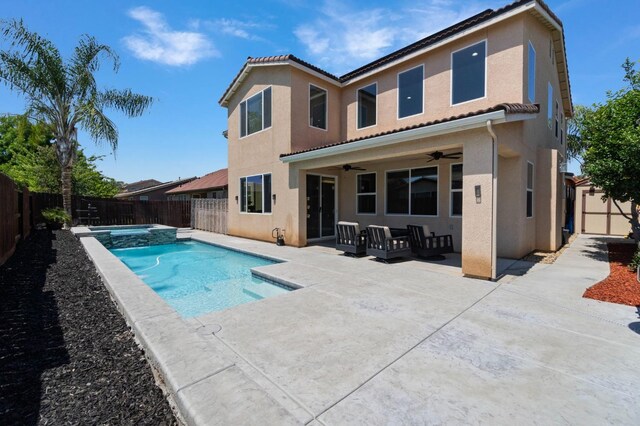 rear view of property with a fenced backyard, a ceiling fan, and stucco siding