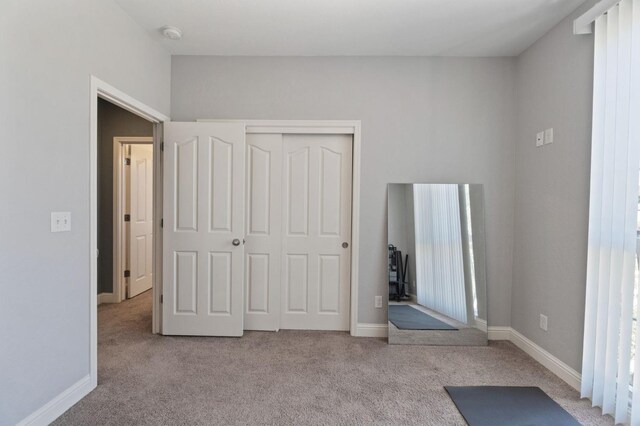 unfurnished bedroom featuring a closet, carpet, and baseboards