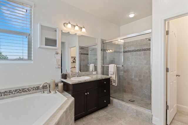 full bathroom with a garden tub, plenty of natural light, vanity, and a shower stall