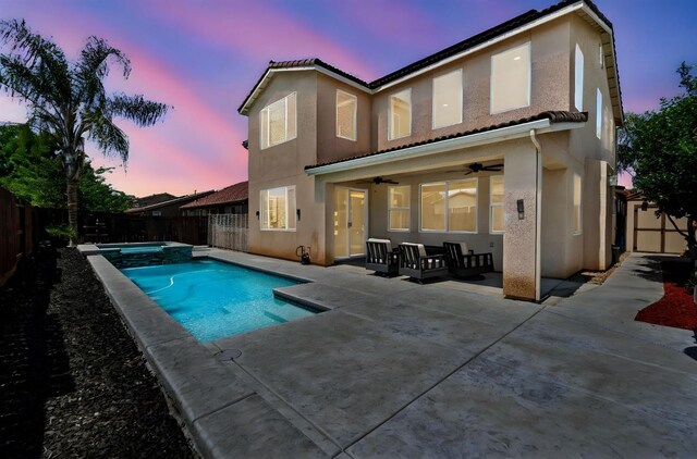 rear view of property featuring a fenced backyard, ceiling fan, a patio area, and stucco siding