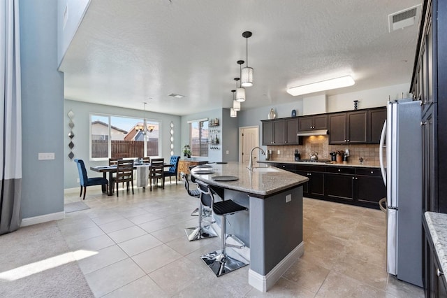 3772 Wrenwood Ave, Clovis, CA 93619 - kitchen featuring a sink, visible vents, backsplash, appliances with stainless steel finishes, and light stone counters
