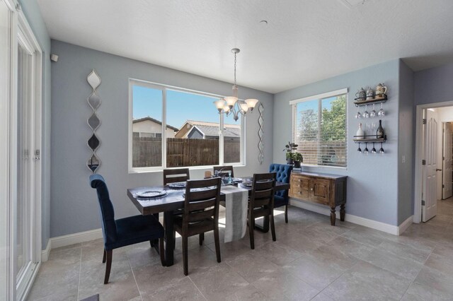 dining area featuring baseboards and a notable chandelier