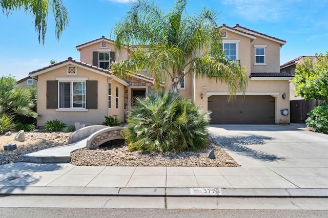 view of front of property featuring a tile roof, a garage, fence, concrete driveway, and stucco siding