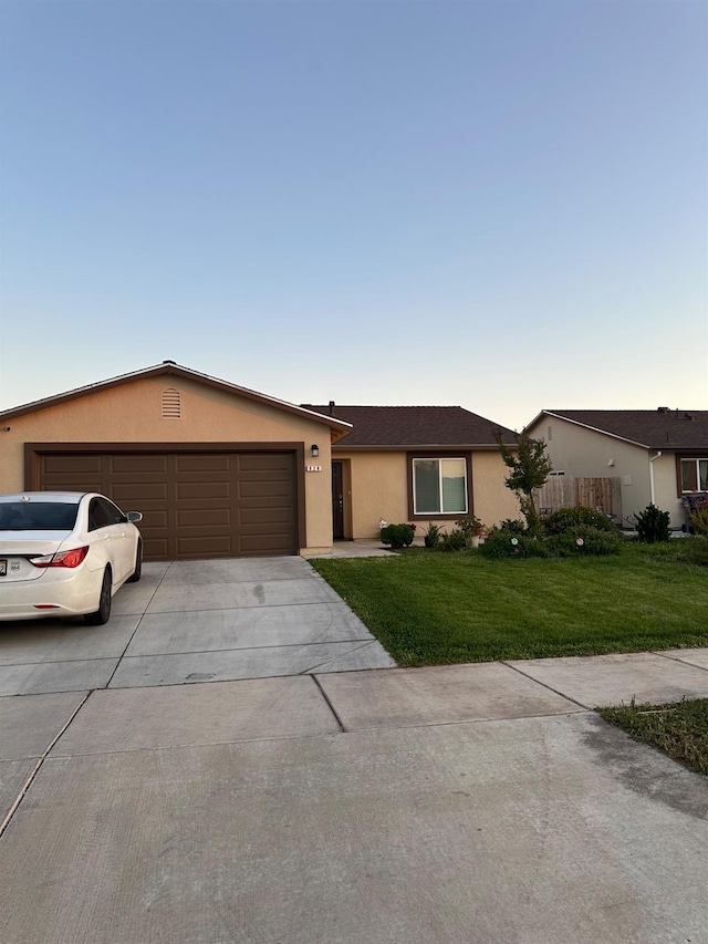 628 Marcus Ave, Merced, CA 95341 - ranch-style home featuring a garage, driveway, a front lawn, and stucco siding
