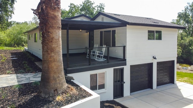 view of front of home with driveway, a shingled roof, and a garage