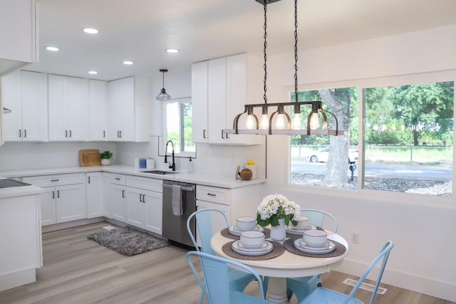 kitchen with white cabinetry, a sink, light countertops, dishwasher, and light wood-style flooring