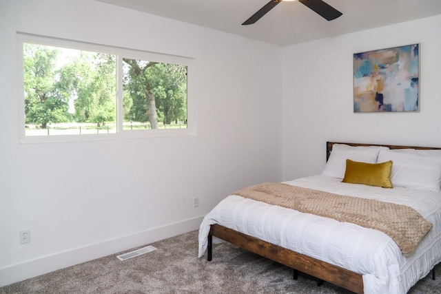 carpeted bedroom featuring baseboards, ceiling fan, and visible vents