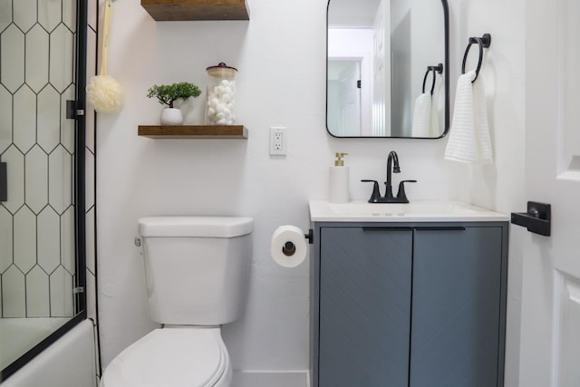 bathroom featuring vanity, combined bath / shower with glass door, and toilet