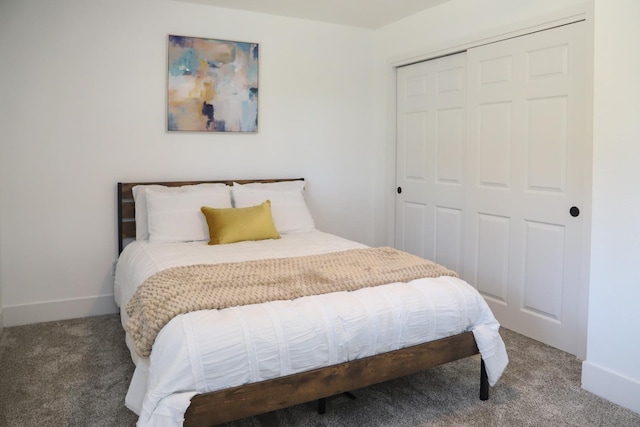 carpeted bedroom featuring a closet and baseboards