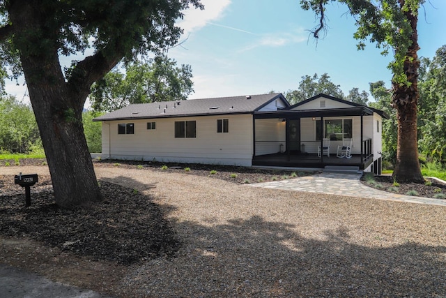 rear view of property featuring covered porch
