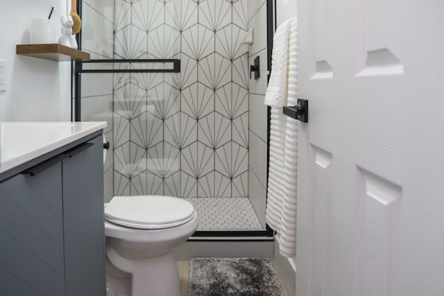 bathroom with vanity, a stall shower, and toilet