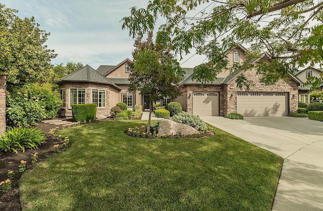 view of front facade featuring a garage, a front yard, stone siding, and concrete driveway