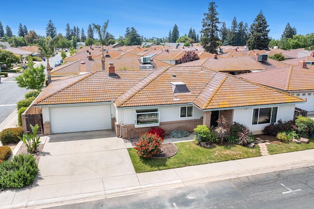 view of front facade with a tile roof, a residential view, a garage, concrete driveway, and stucco siding